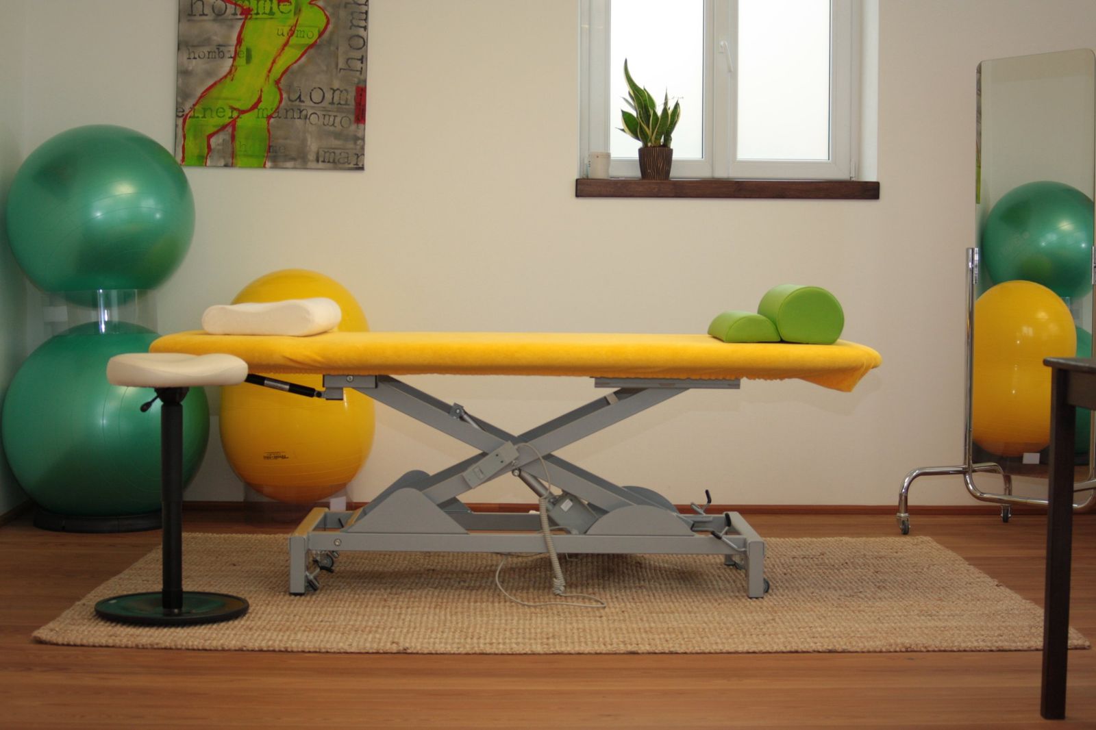 Therapieraum mit Behandlungsliege und Gymnastikbällen